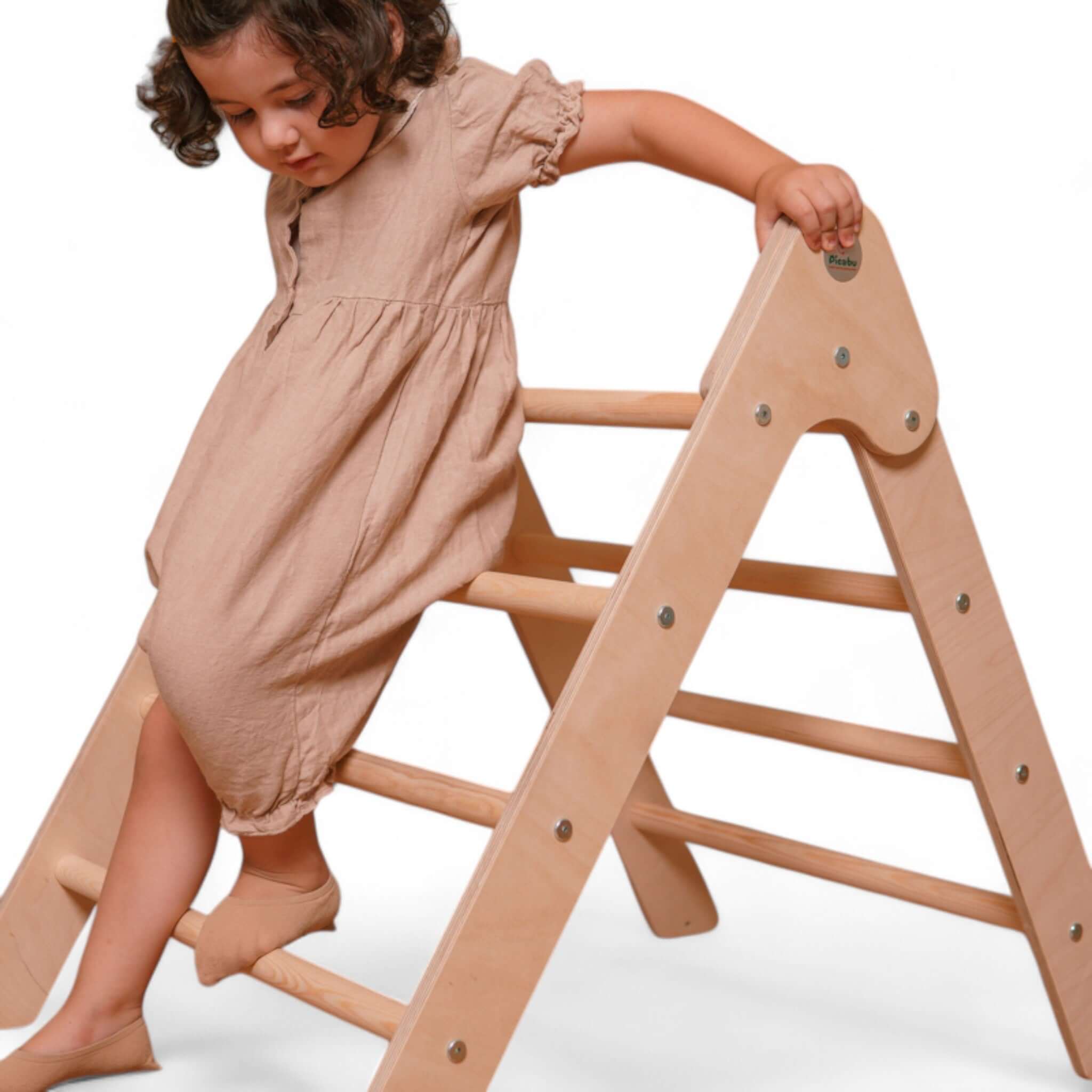 Kind spielt auf dem klappbaren Pikler Kletterdreieck aus Holz, inspiriert von Montessori-Pädagogik.